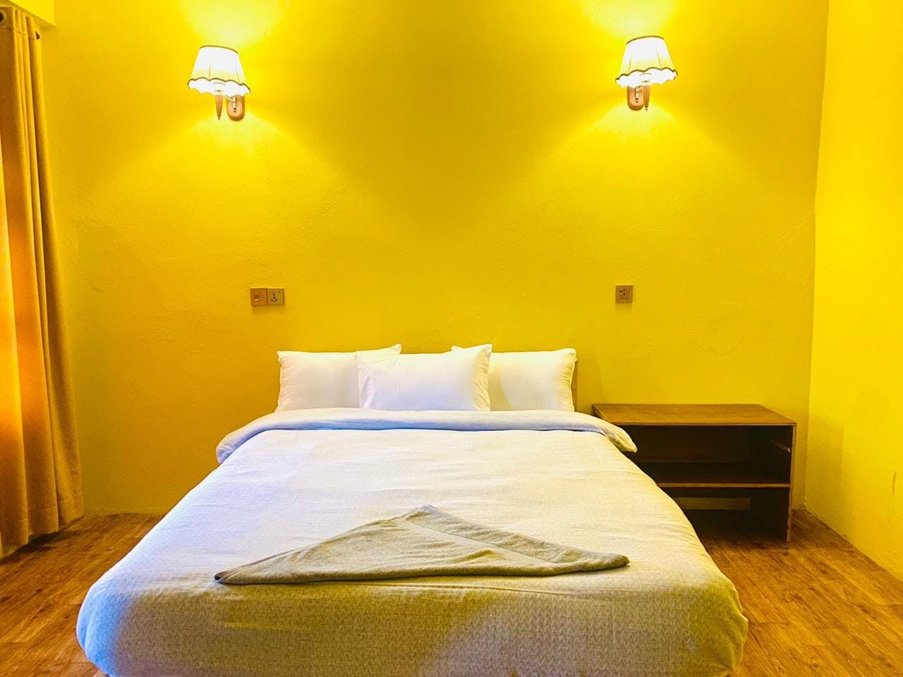 Cozy hotel room with warm lighting and a comfortable bed